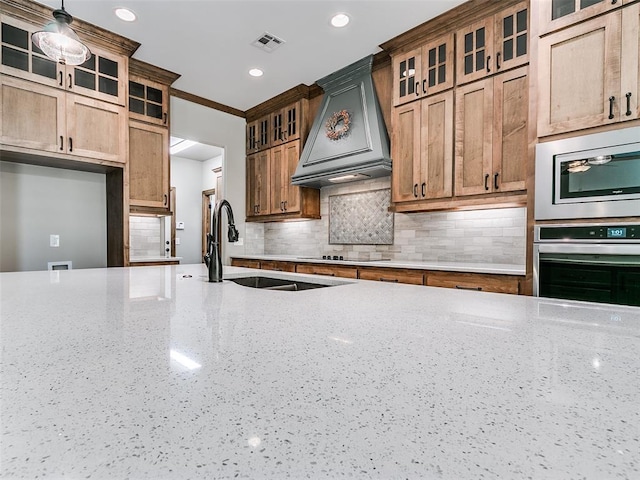 kitchen featuring stainless steel appliances, premium range hood, backsplash, crown molding, and pendant lighting