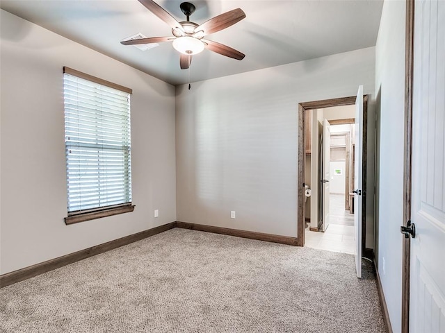 empty room featuring light colored carpet and ceiling fan