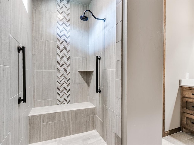 bathroom featuring a tile shower and vanity