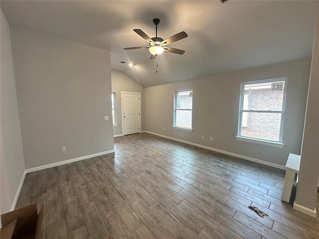 spare room featuring hardwood / wood-style flooring, vaulted ceiling, and ceiling fan