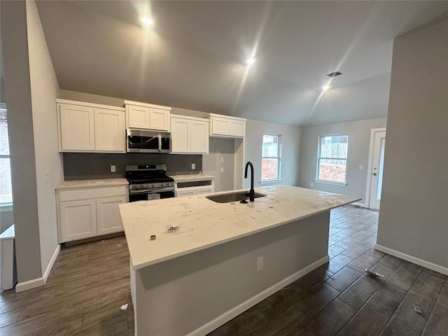 kitchen featuring stainless steel appliances, sink, a center island with sink, and white cabinets