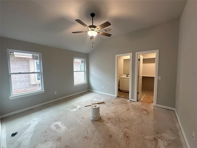 unfurnished bedroom with lofted ceiling, sink, ceiling fan, ensuite bathroom, and a spacious closet