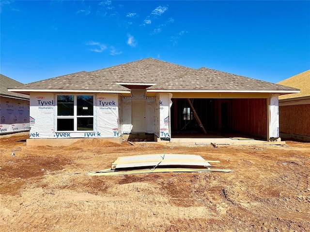 back of house with roof with shingles