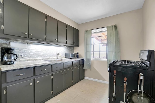 kitchen featuring backsplash, gray cabinetry, and sink