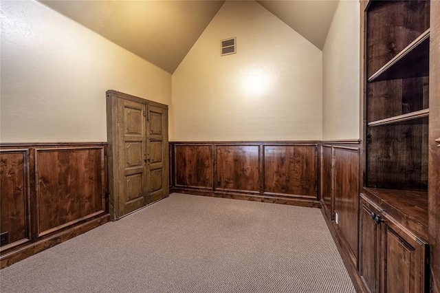 additional living space with wood walls, carpet floors, and vaulted ceiling