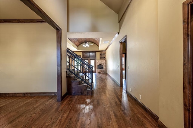 entryway featuring a fireplace, ceiling fan, and dark wood-type flooring