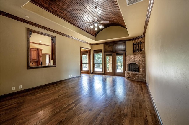 unfurnished living room with dark hardwood / wood-style flooring, a brick fireplace, vaulted ceiling, ceiling fan, and crown molding