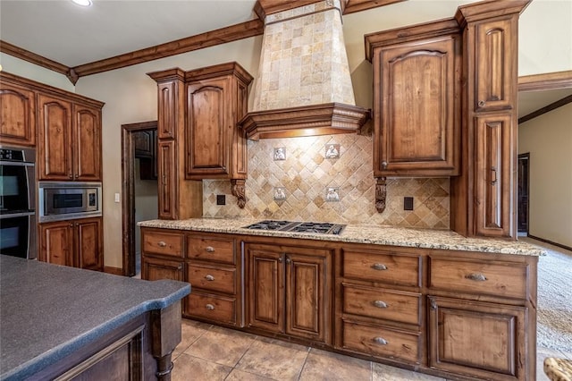 kitchen with light tile patterned flooring, appliances with stainless steel finishes, crown molding, and custom exhaust hood