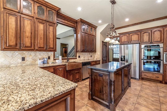 kitchen featuring crown molding, hanging light fixtures, appliances with stainless steel finishes, kitchen peninsula, and a chandelier