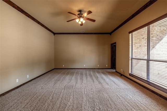 carpeted empty room featuring a wealth of natural light, ceiling fan, and ornamental molding