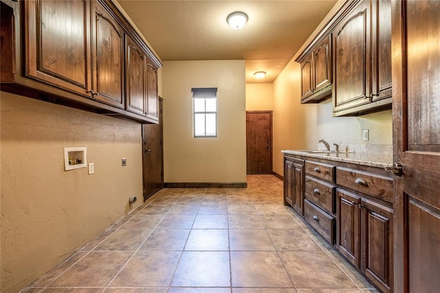 laundry area featuring washer hookup, light tile patterned flooring, cabinets, and sink