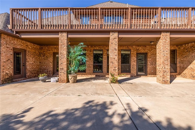 rear view of house with a patio and a balcony