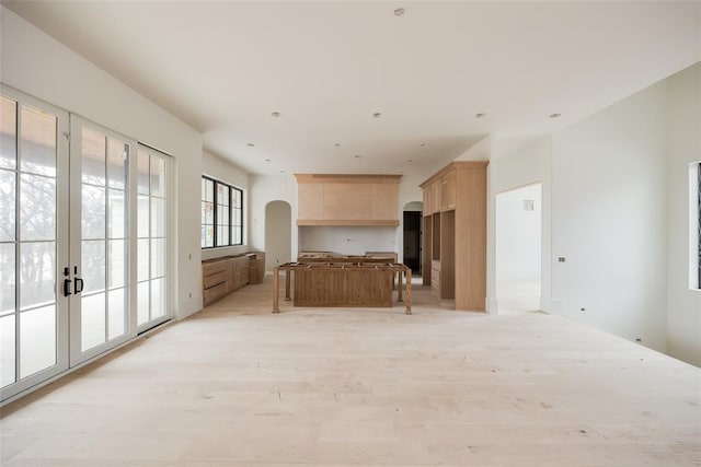 kitchen with light brown cabinets, a kitchen island, and light wood-type flooring