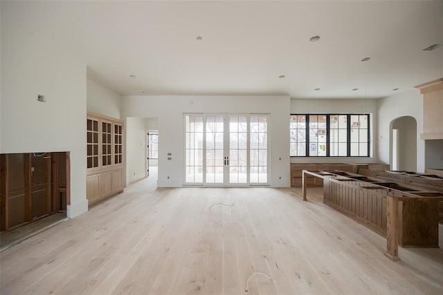 unfurnished living room with french doors and light wood-type flooring