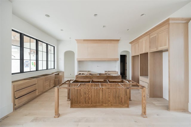 kitchen featuring light brown cabinetry, a kitchen island, and light hardwood / wood-style flooring