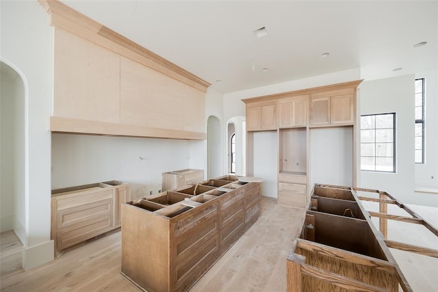 kitchen with a center island, light brown cabinetry, and light hardwood / wood-style floors