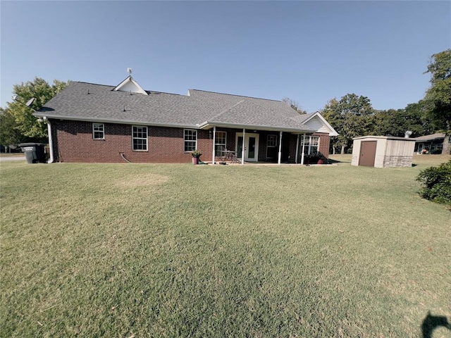 rear view of property with a storage unit and a lawn