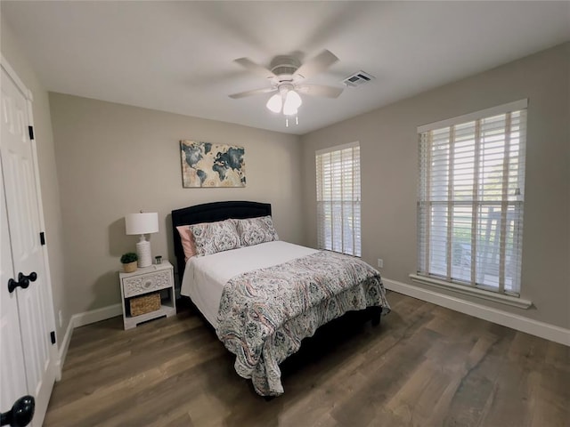 bedroom with dark hardwood / wood-style flooring and ceiling fan