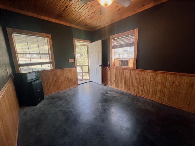 unfurnished room featuring wood walls, ceiling fan, and wood ceiling