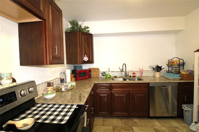 kitchen featuring light stone countertops, sink, and stainless steel appliances