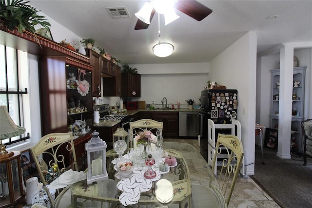 kitchen featuring ceiling fan, sink, stainless steel appliances, light carpet, and dark brown cabinets