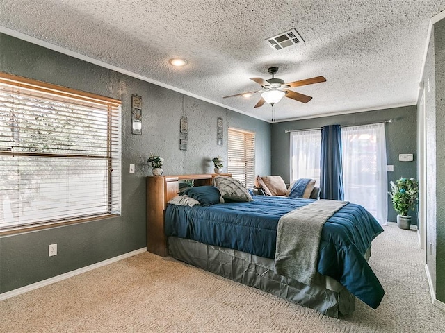 bedroom with multiple windows, a textured ceiling, carpet floors, and ceiling fan