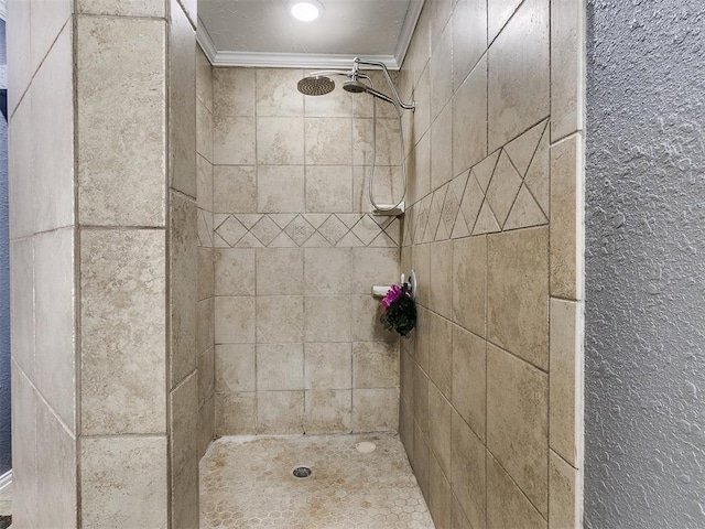 bathroom with tiled shower and crown molding