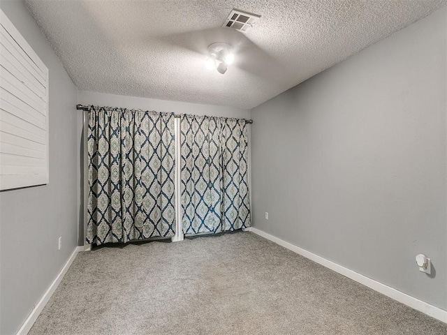 empty room featuring carpet floors and a textured ceiling