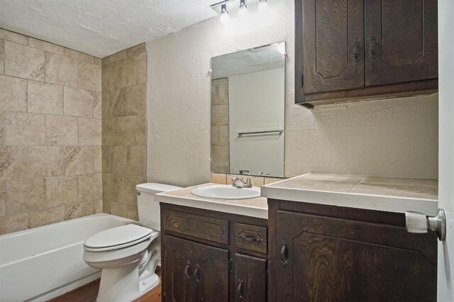 5825 NW 34th St, Oklahoma City, OK 73122 - bathroom featuring a textured wall, vanity, toilet, a textured ceiling, and shower / bath combination