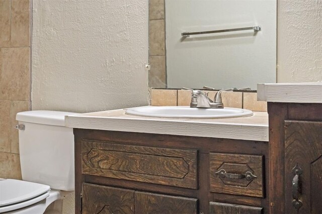 5825 NW 34th St, Oklahoma City, OK 73122 - bathroom featuring toilet, a textured wall, and vanity