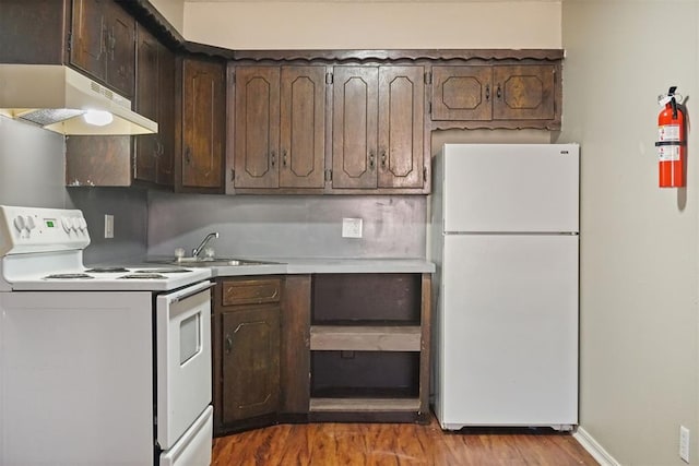 5825 NW 34th St, Oklahoma City, OK 73122 - kitchen with white appliances, under cabinet range hood, wood finished floors, dark brown cabinetry, and a sink