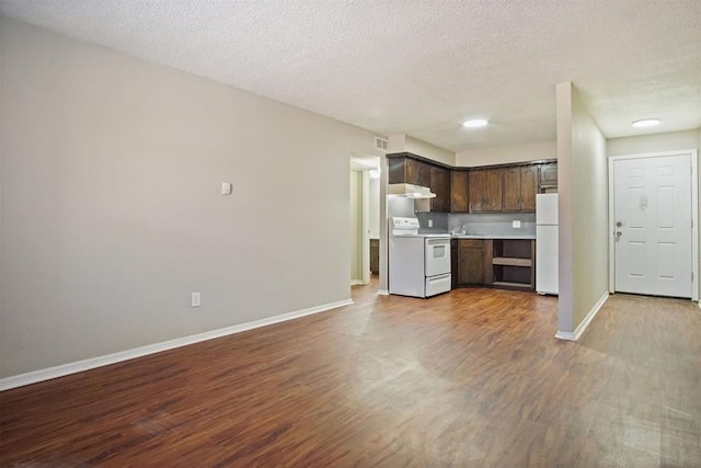 kitchen with dark brown cabinets, white appliances, hardwood / wood-style flooring, and a textured ceiling