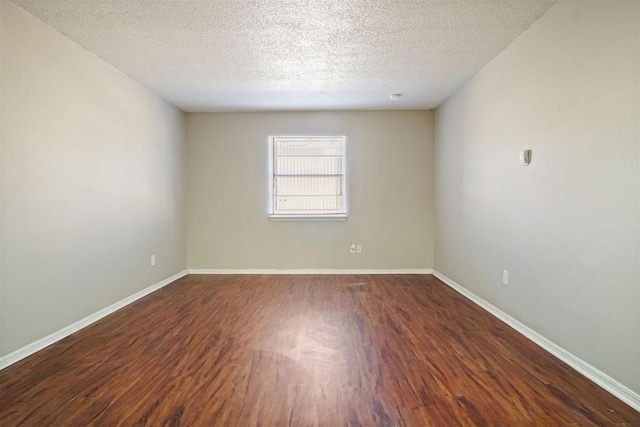 empty room featuring a textured ceiling and dark wood-type flooring