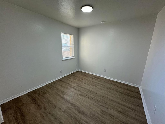 unfurnished room featuring dark wood-type flooring