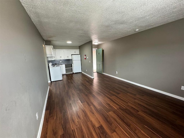 5825 NW 34th St, Oklahoma City, OK 73122 - unfurnished living room with baseboards, a textured ceiling, and dark wood-type flooring