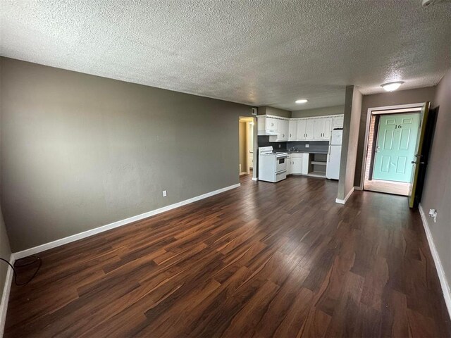 5825 NW 34th St, Oklahoma City, OK 73122 - unfurnished living room with baseboards, a textured ceiling, and dark wood-style flooring