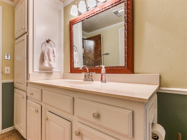 bathroom with hardwood / wood-style flooring, vanity, and ornamental molding