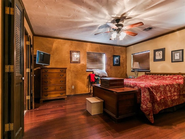 bedroom with dark hardwood / wood-style floors, ceiling fan, and crown molding