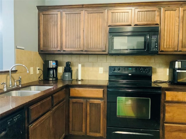 kitchen with black appliances, sink, dark stone counters, and tasteful backsplash