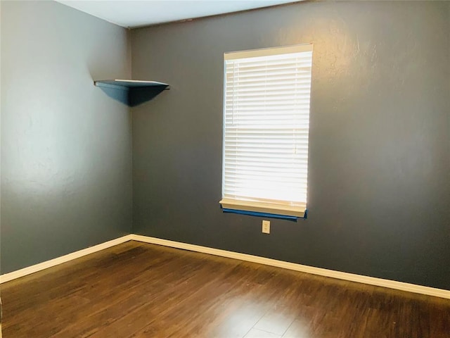 spare room featuring hardwood / wood-style floors and plenty of natural light