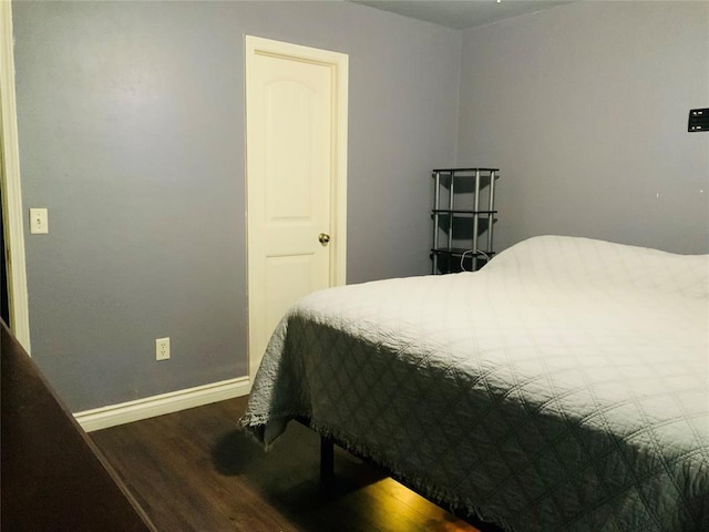 bedroom with dark hardwood / wood-style floors