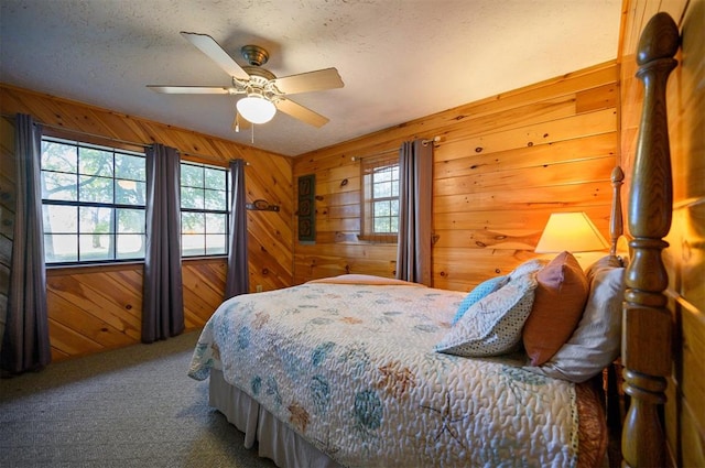 carpeted bedroom with ceiling fan and wooden walls