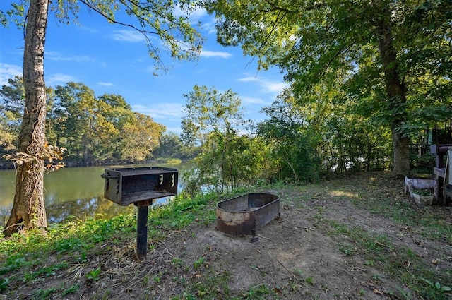 view of yard with a water view and an outdoor fire pit