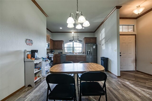 dining area featuring a notable chandelier, crown molding, and dark wood-type flooring