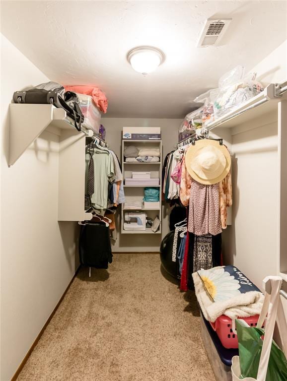 walk in closet featuring light colored carpet