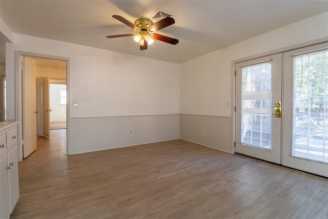 spare room featuring french doors and light hardwood / wood-style floors