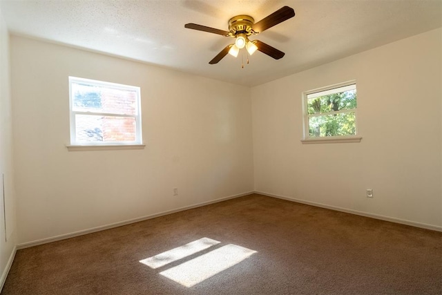 carpeted spare room featuring ceiling fan and a textured ceiling