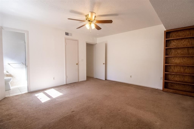 unfurnished bedroom featuring carpet, ceiling fan, a textured ceiling, and connected bathroom