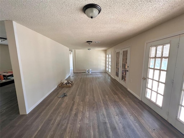 interior space with dark hardwood / wood-style flooring, french doors, and a textured ceiling