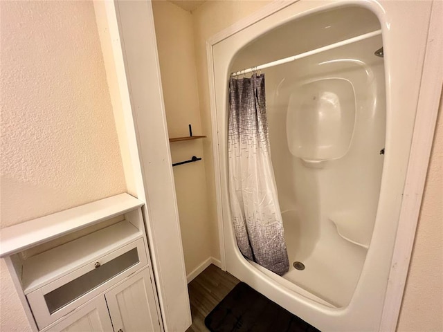 bathroom with hardwood / wood-style flooring and curtained shower